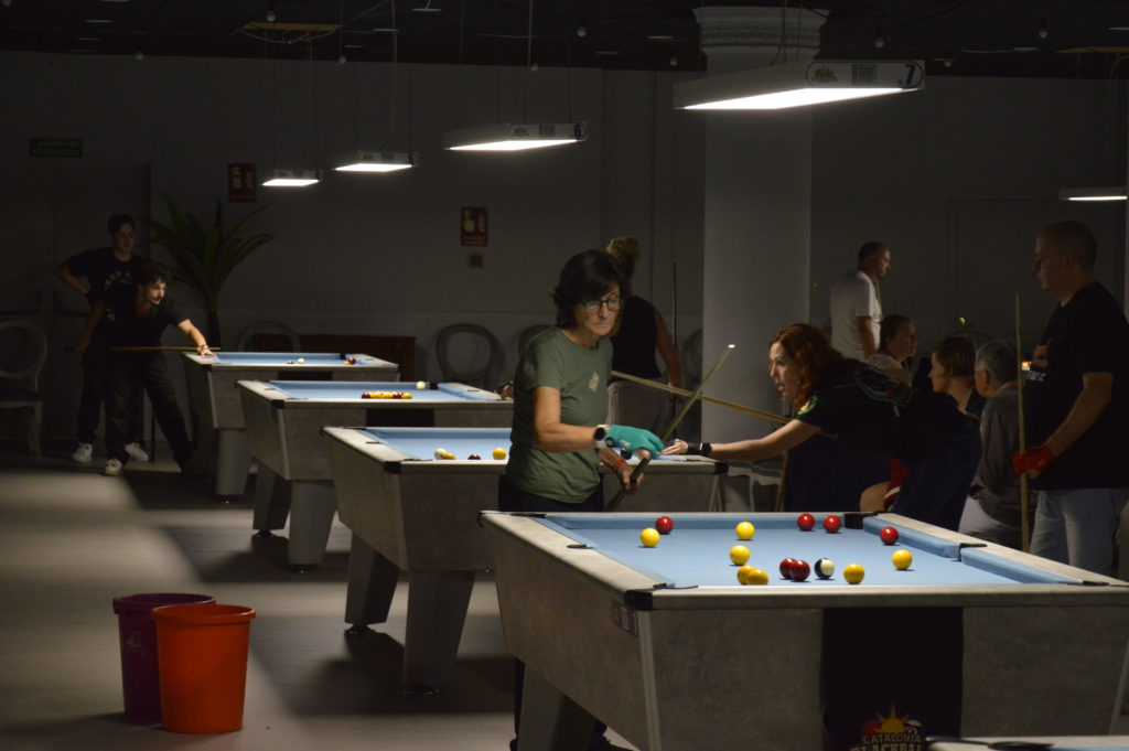 La salle du Catalonia Blackball Party 2026 a La Pineda : plusieurs billards en jeu, joueuses et joueurs autour des tables